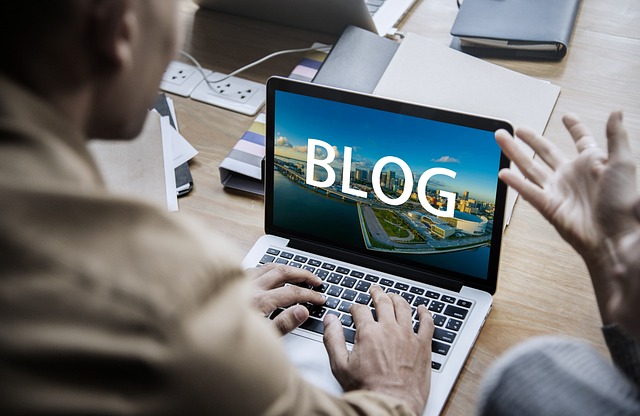 A person typing on a laptop with the word 'BLOG' displayed prominently on the screen.