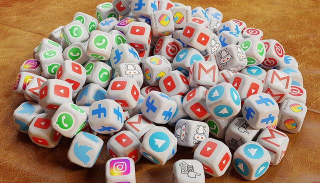 A pile of dice featuring various social media and communication platform logos like Facebook, YouTube, Instagram, and Twitter.