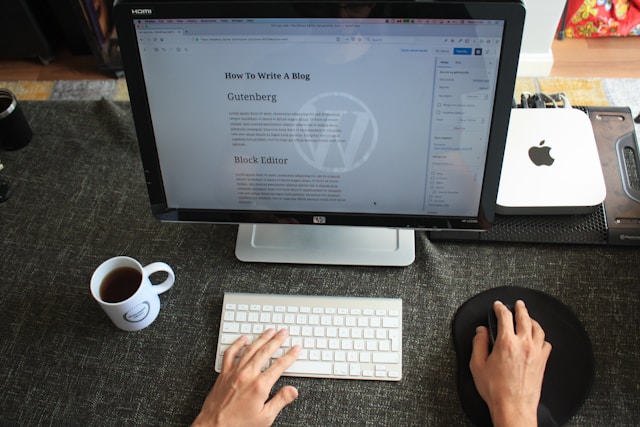 An overhead view of a blogger working on a WordPress post titled 'How to Write a Blog,' with hands on a keyboard.