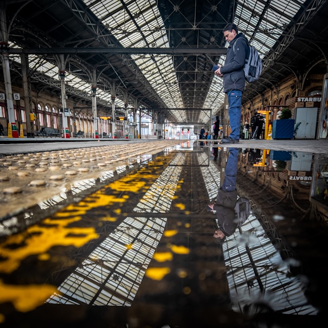 A traveler at a bustling train station, reflecting adventure and journey—a perfect moment for a travel blog story.