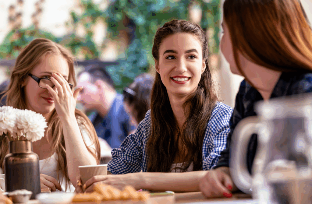 Three women talking in a café over coffee.